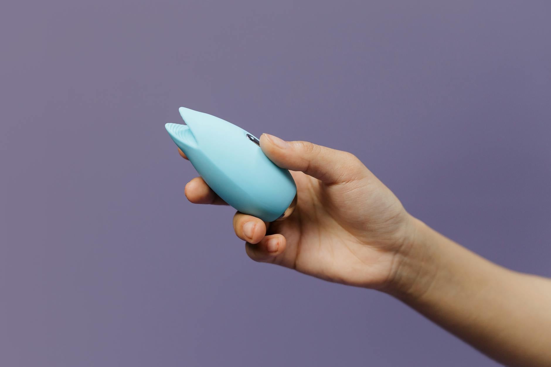 Close-up of a lemon clitoral vibrator held in hand, representing pleasure and self-care